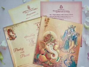 Radha Krishna With Peacocks Themed Orange Ganesha Wedding Invitation Card